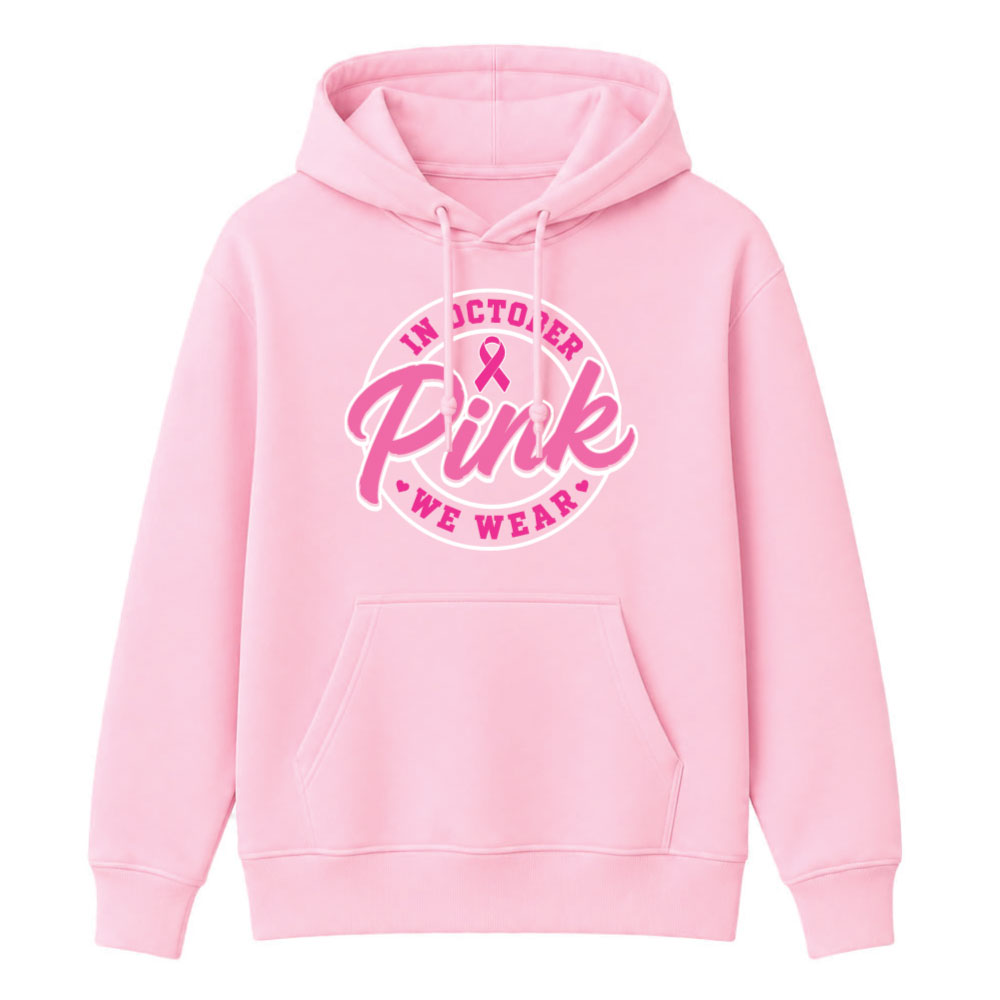Circular "In October We Wear Pink" breast cancer awareness design featuring a pink ribbon and bold script lettering for custom Pink Out shirts and fundraiser apparel.